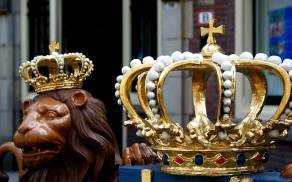 Beeld van leeuw met kroontje, en op de voorgrond grote grouden kroon