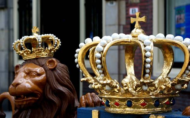Beeld van leeuw met kroontje, en op de voorgrond grote grouden kroon